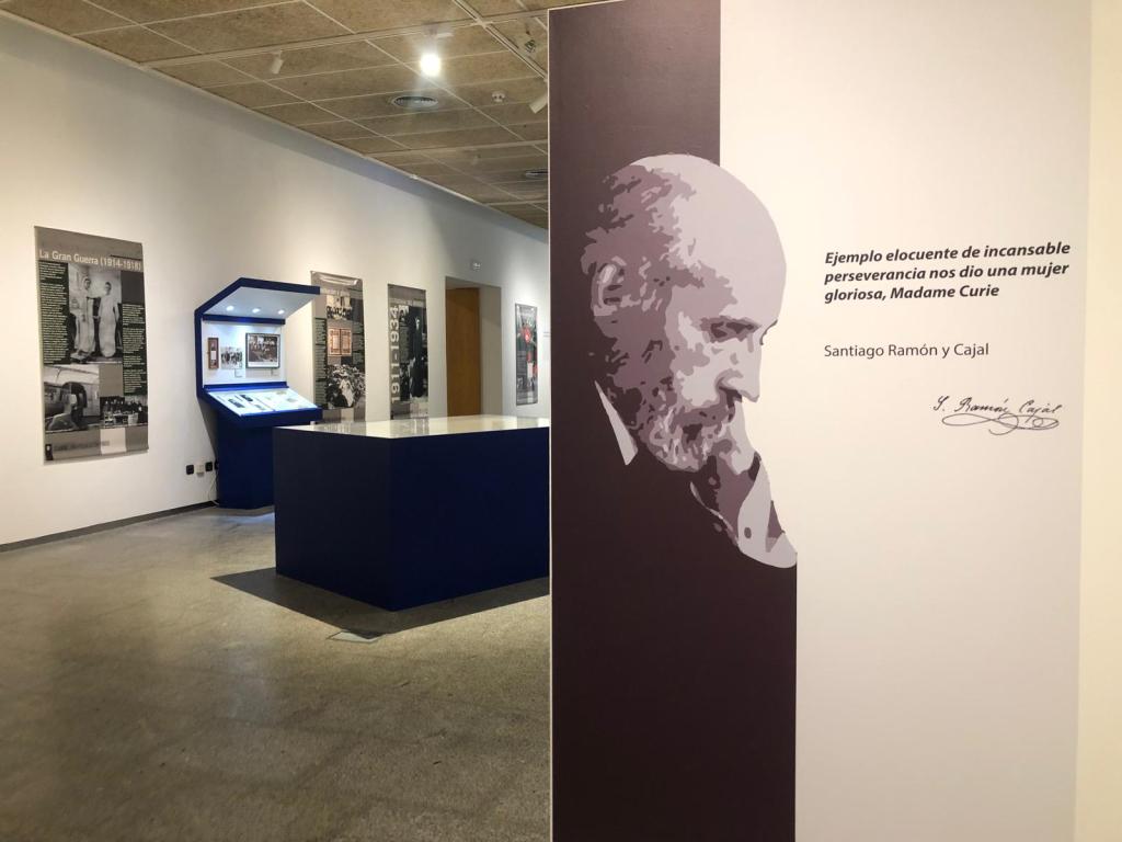 Exhibition hall about Maria Sklodowska-Curie with informational panels and a portrait of Santiago Ramon y Cajal, highlighting his phrase about the perseverance of Madame Curie.