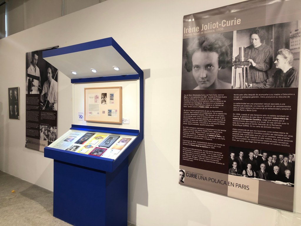 Display of the biography of Irene Joliot-Curie, with informational panels and archival objects about her life and achievements, at the exhibition dedicated to Maria Sklodowska-Curie.