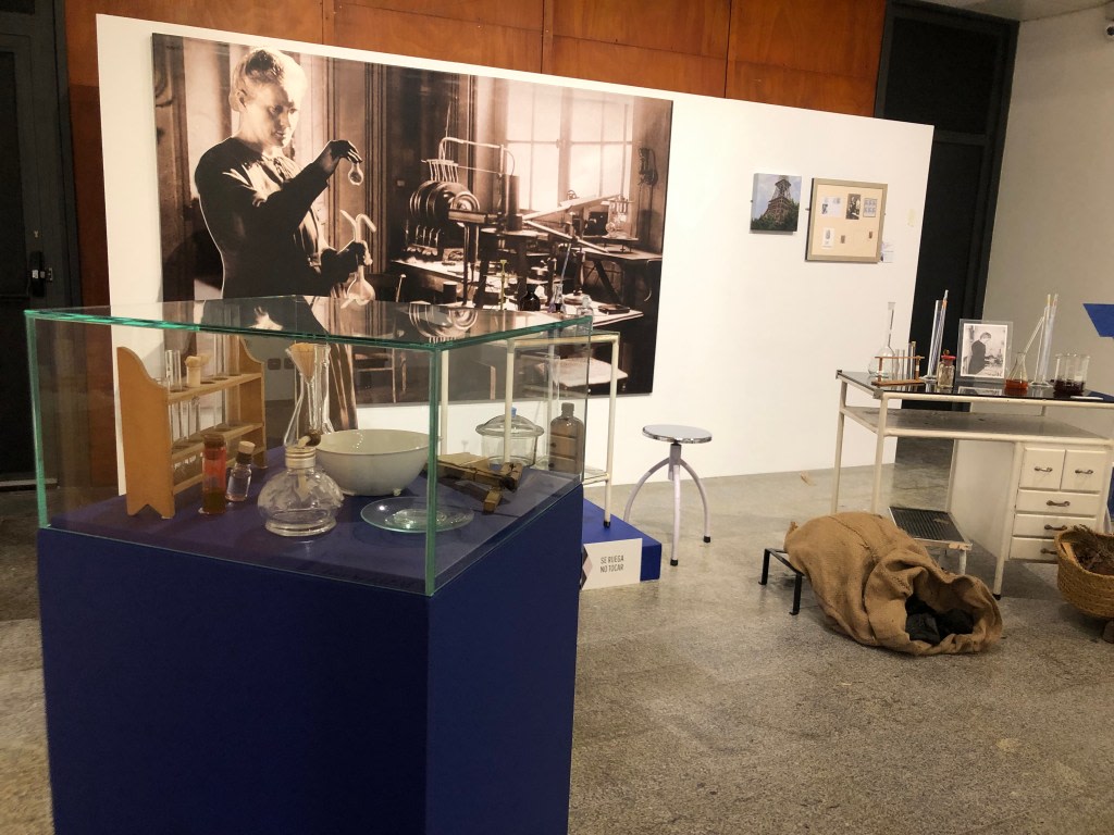 Display dedicated to Maria Sklodowska-Curie, with a laboratory table and glass flasks, in the context of the traveling exhibition about her life and work.