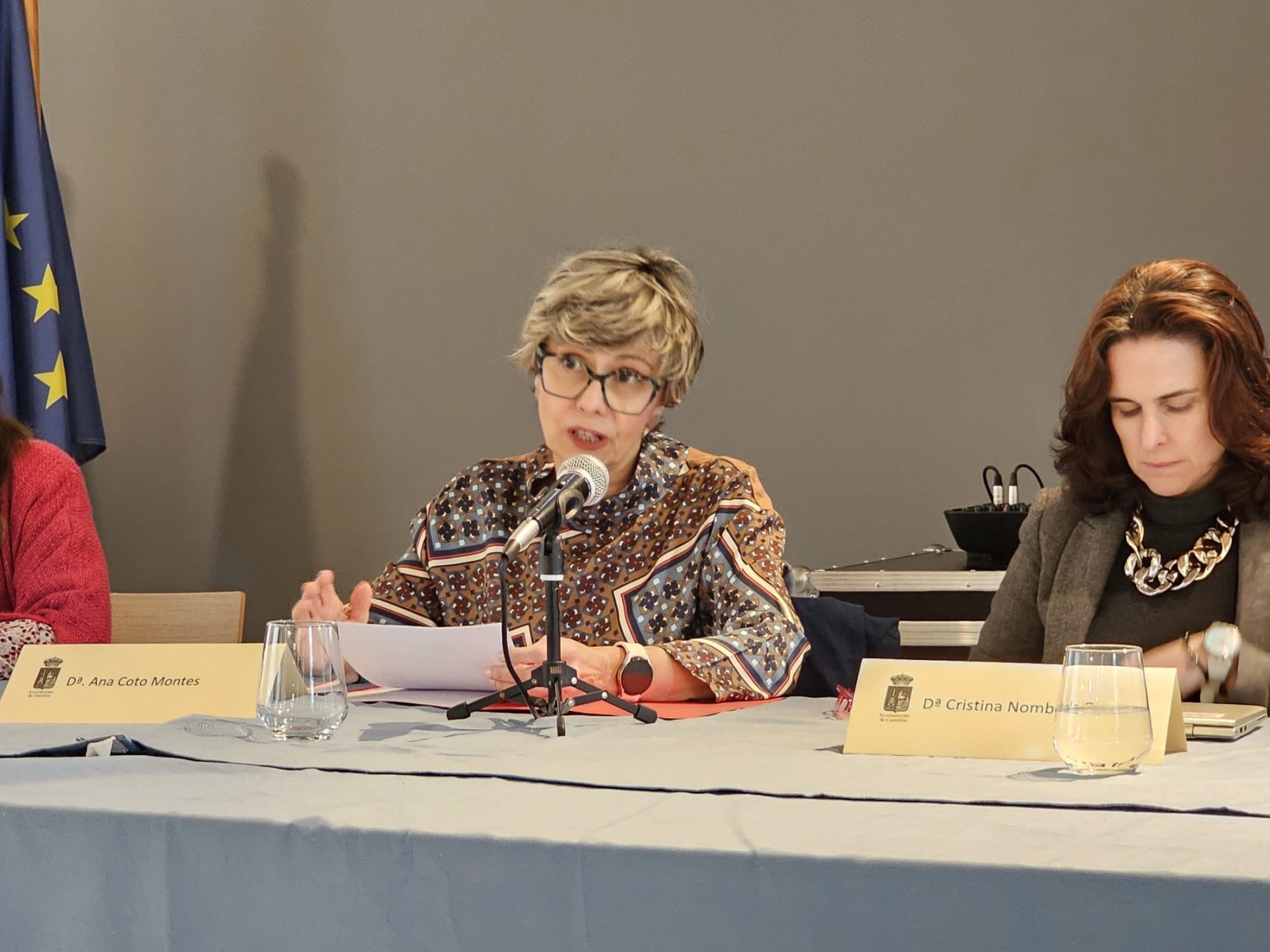 Dr. Ana Coto Montes, Professor of Cell Biology, speaking at an event, with a presentation on the table.