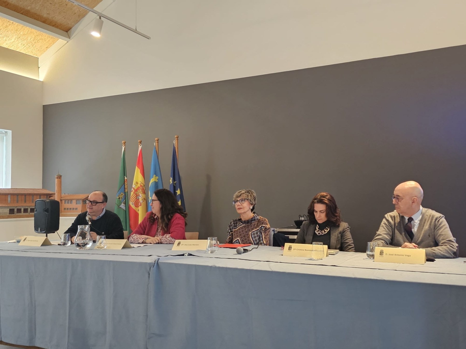 Round table during the tribute event to Santiago Ramón y Cajal at the Arnao Mine Museum, with several speakers and flags of Spain and Asturias in the background.