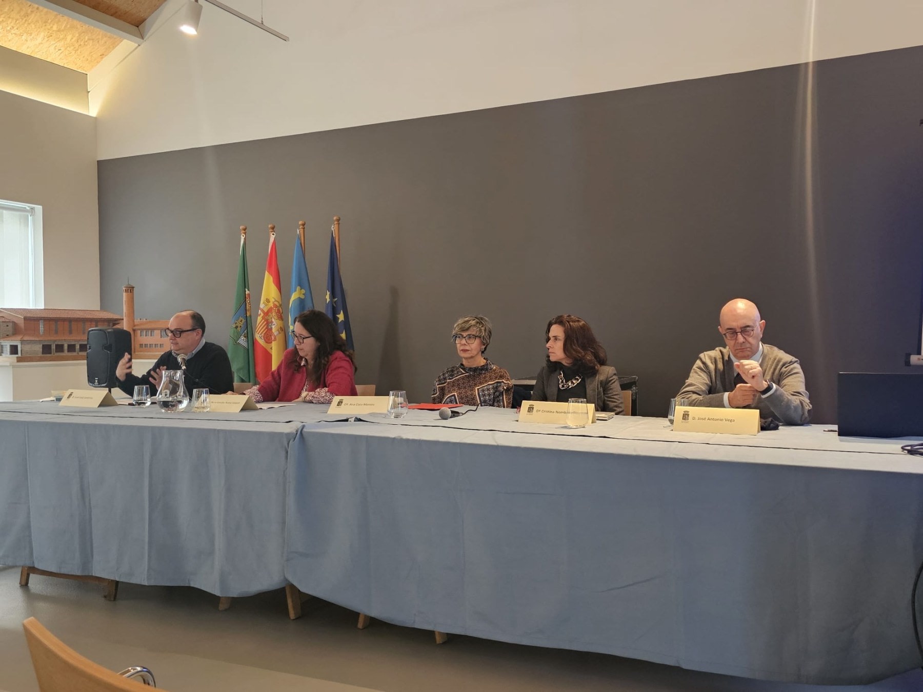Expert panel at an event on science and legacy, with four speakers seated behind a table, presenting at the Arnao Mine Museum.