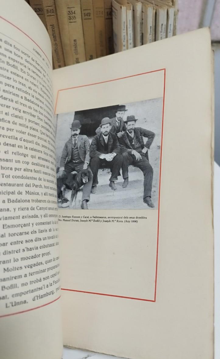 Un grupo de cinco hombres, entre ellos Santiago Ramón y Cajal, posando sentados en un escalón con un perro, en un escenario al aire libre, acompañado de libros. La imagen data del año 1890.