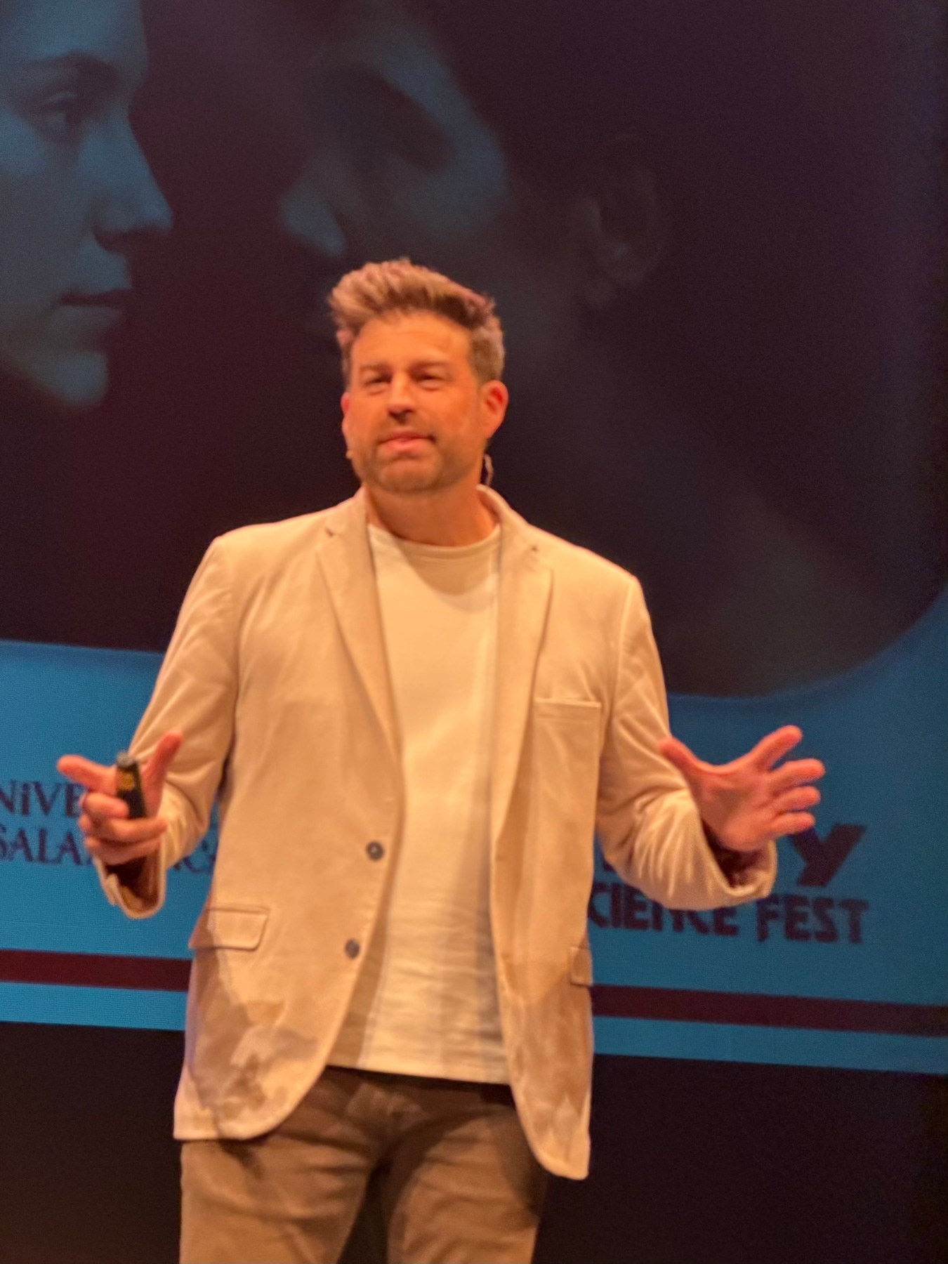 Ponente en el MUY Science Fest 2025, mostrando gestos de entusiasmo mientras presenta en el Teatro Liceo de Salamanca.